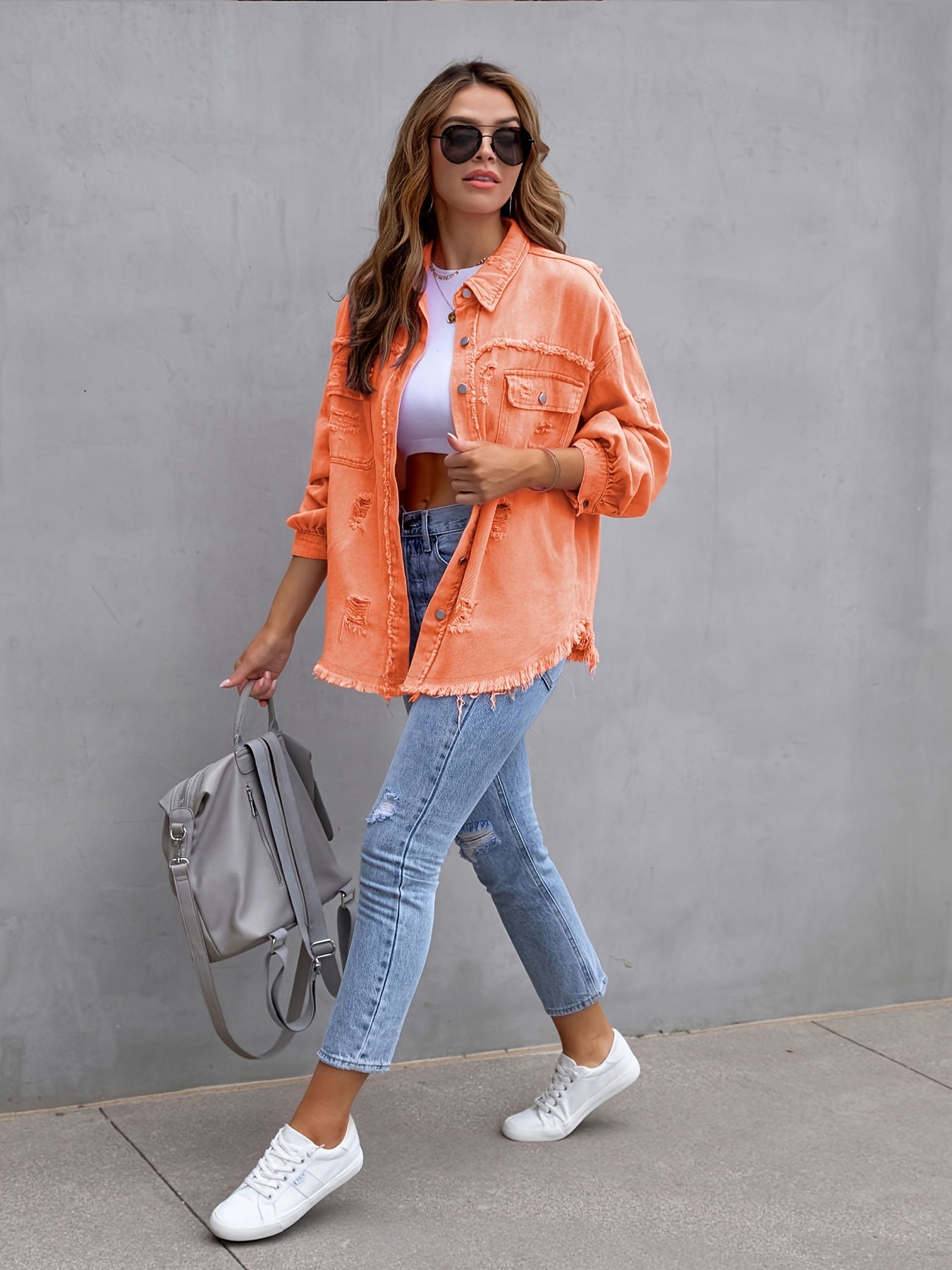 Locker sitzende zerrissene Jeansjacke mit langen Ärmeln